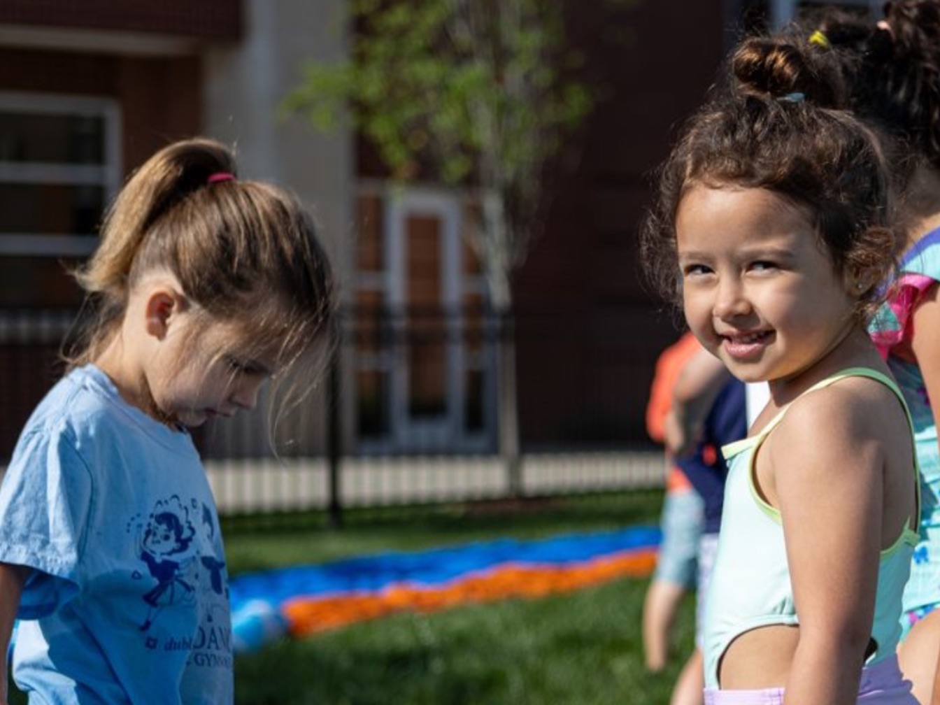 Who young children stand in a kiddy pool.