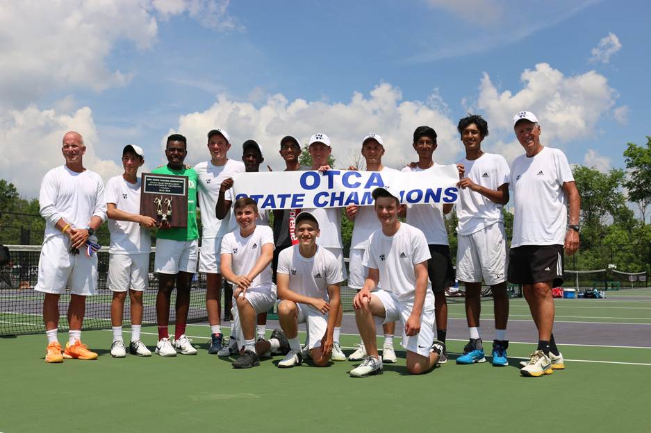 A group of high school tennis players pose outdoors with a sign that reads "OTCA State Champions"