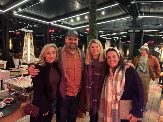 A group of four adults poses for a photo in a restaurant