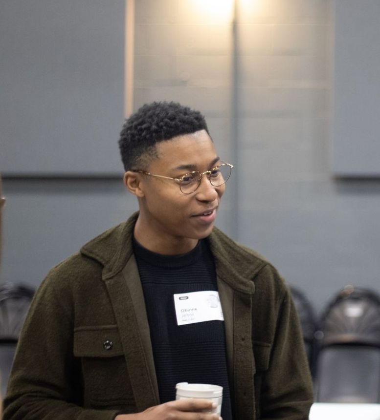 Man in green jacket talks to someone out of frame