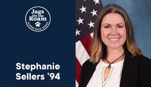 A graphic that says Stephanie Sellers and has a picture of a woman posing for a headshot in front of the flag of the United States